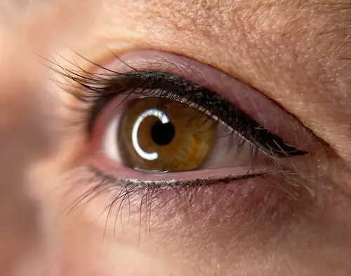 micropigmentacion Primer plano de un ojo marrón con delineador negro en el párpado superior, mostrando los efectos de la micropigmentación en ojos y resaltando las pestañas y la textura de la piel alrededor del ojo. Monica Aranguez