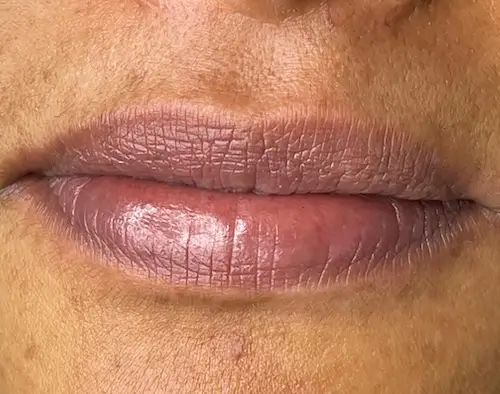 micropigmentacion Primer plano de los labios de una persona con expresión neutra, ligeramente agrietados, pero sutilmente realzados por la micropigmentación labial. El tono rosado natural resalta a la perfección sobre un tono de piel bronceado. Monica Aranguez